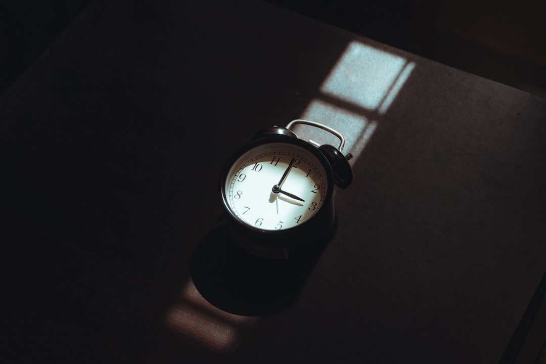 alarm clock on nightstand dark bedroom early morning