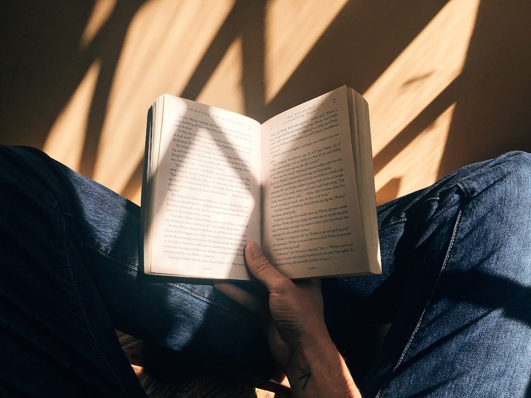 Pessoa lendo um livro em uma estante de biblioteca