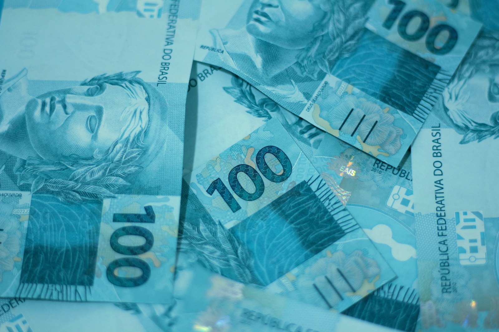 Varias cedulas de cem reais espalhadas sobre uma superficie