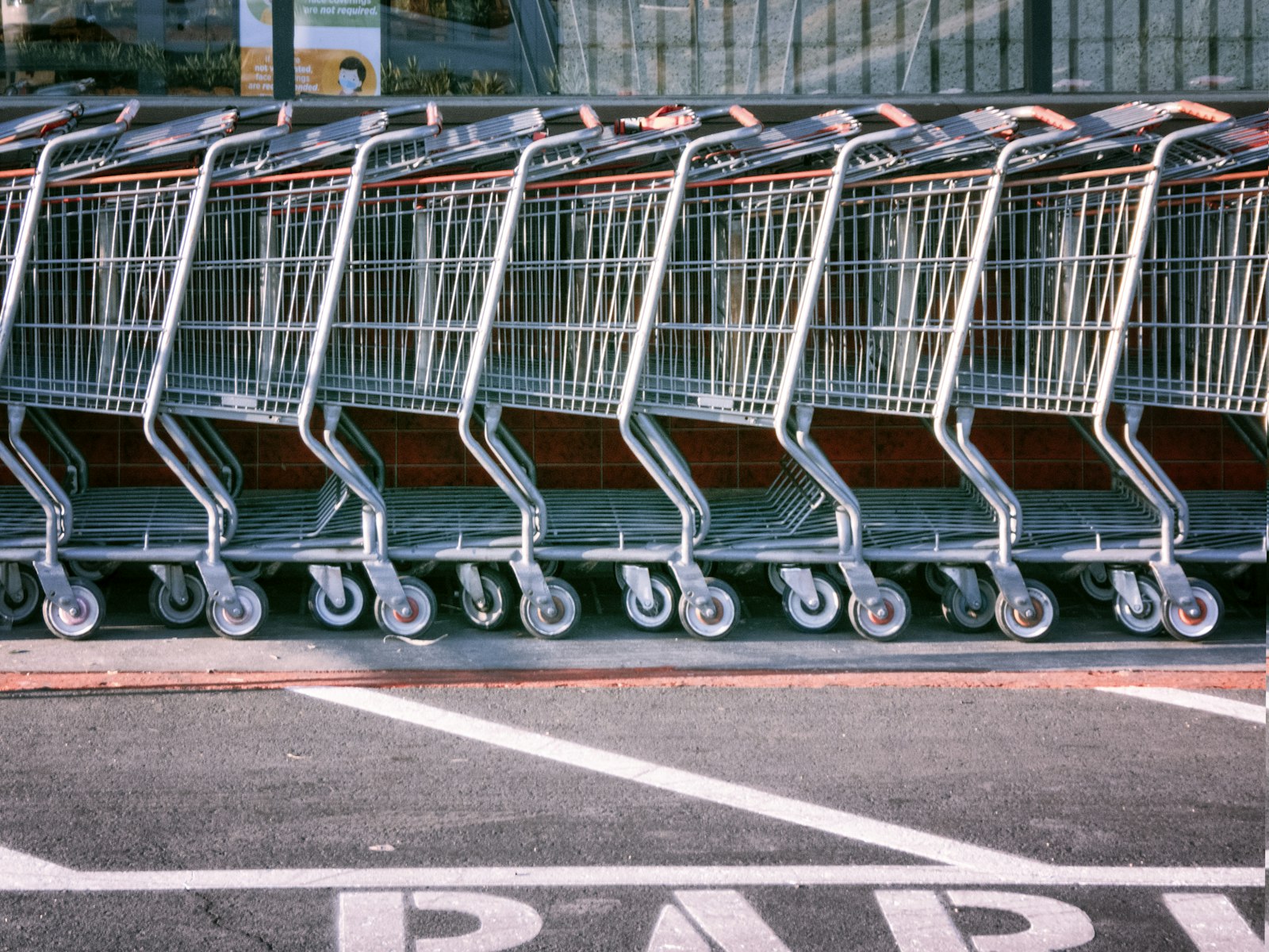 Fileira de carrinhos de supermercado encaixados em um estacionamento