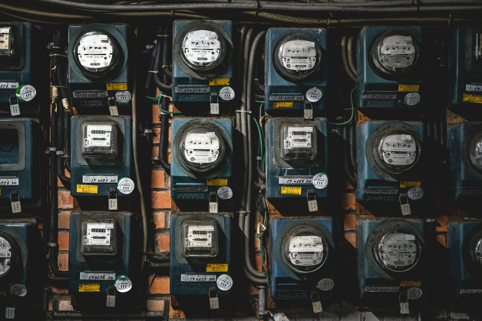 Vários medidores de energia elétrica instalados lado a lado na parede