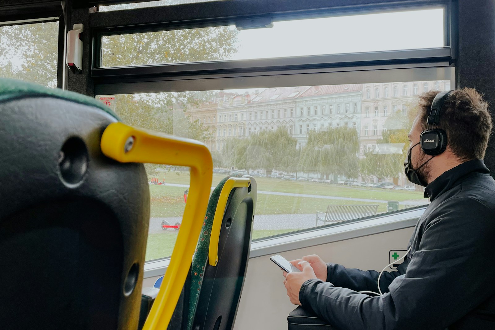 Homem de fone de ouvido sentado dentro de um ônibus