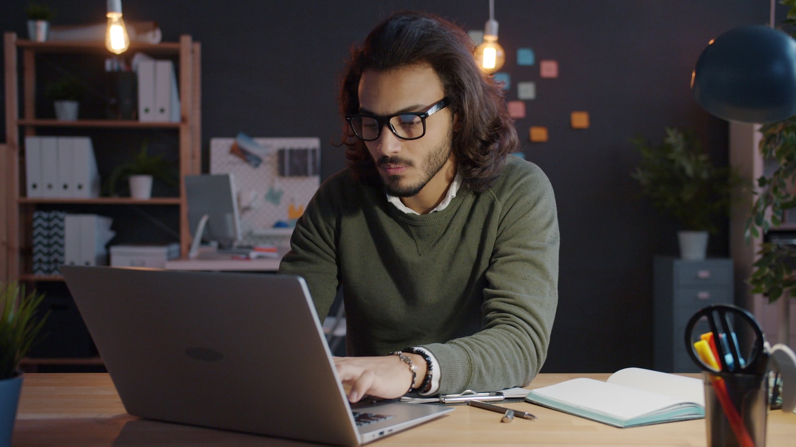 Homem trabalhando no notebook em escritorio com pouca luz