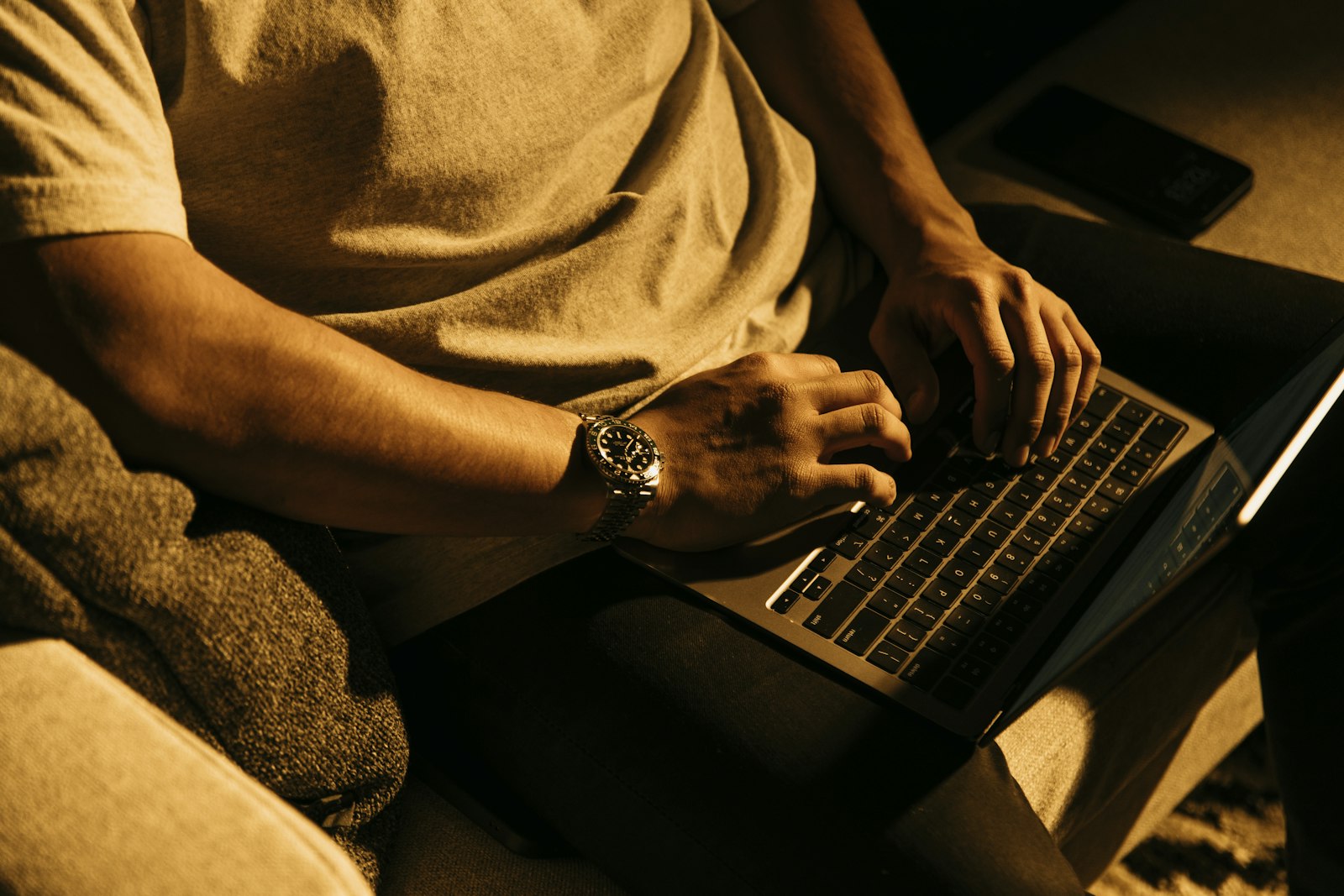 Homem sentado no sofá usando um notebook