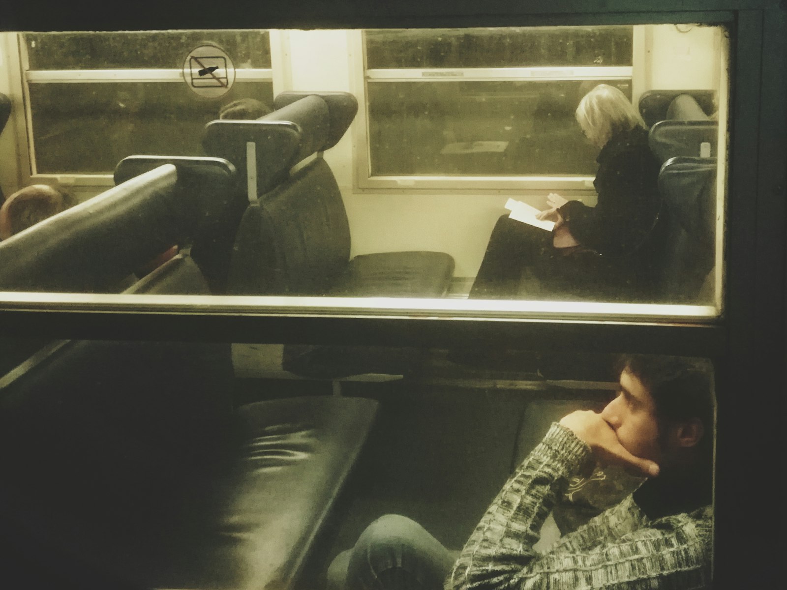 Homem sentado em um trem lendo um livro durante o trajeto