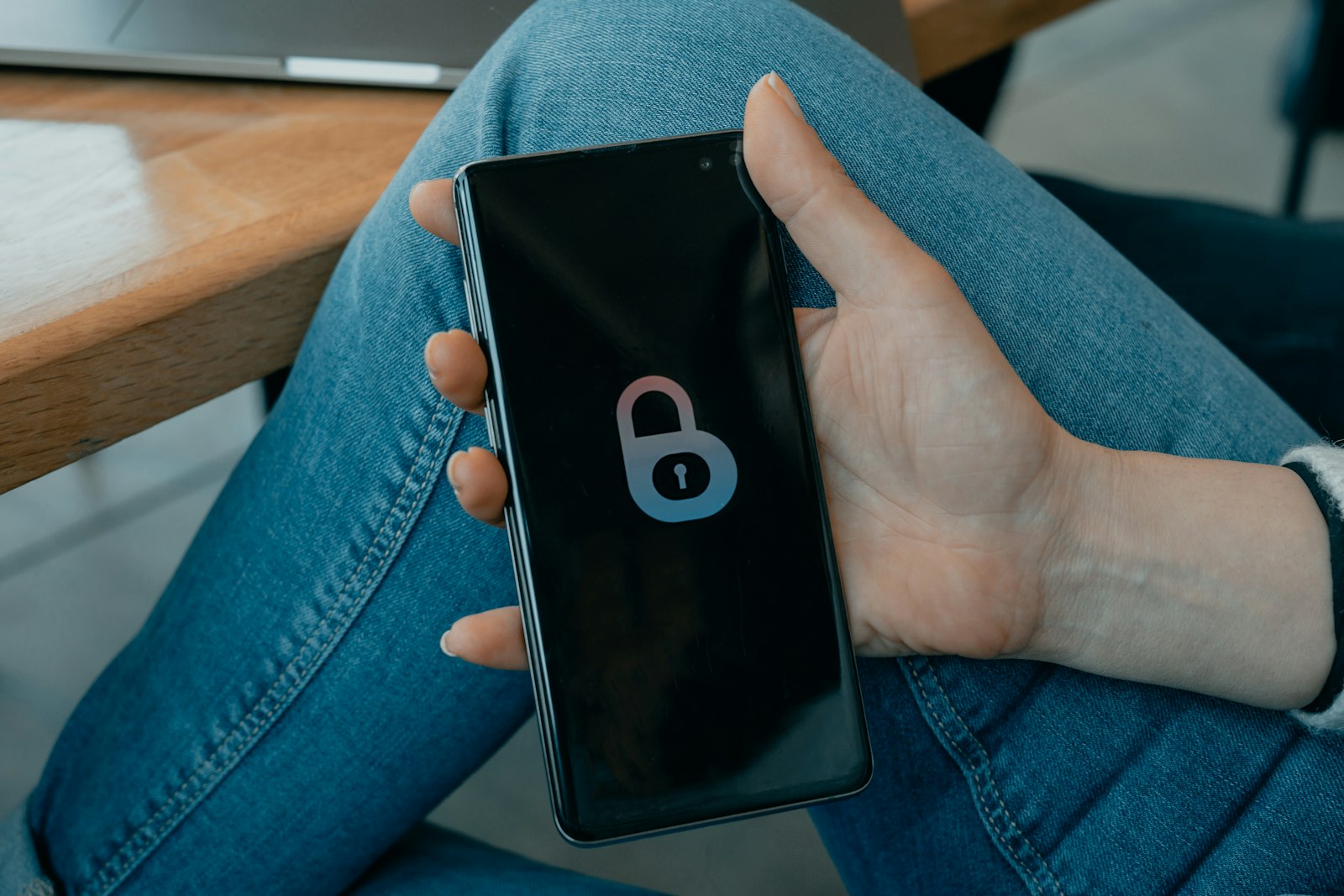 Celular na mao exibindo um icone de cadeado na tela
