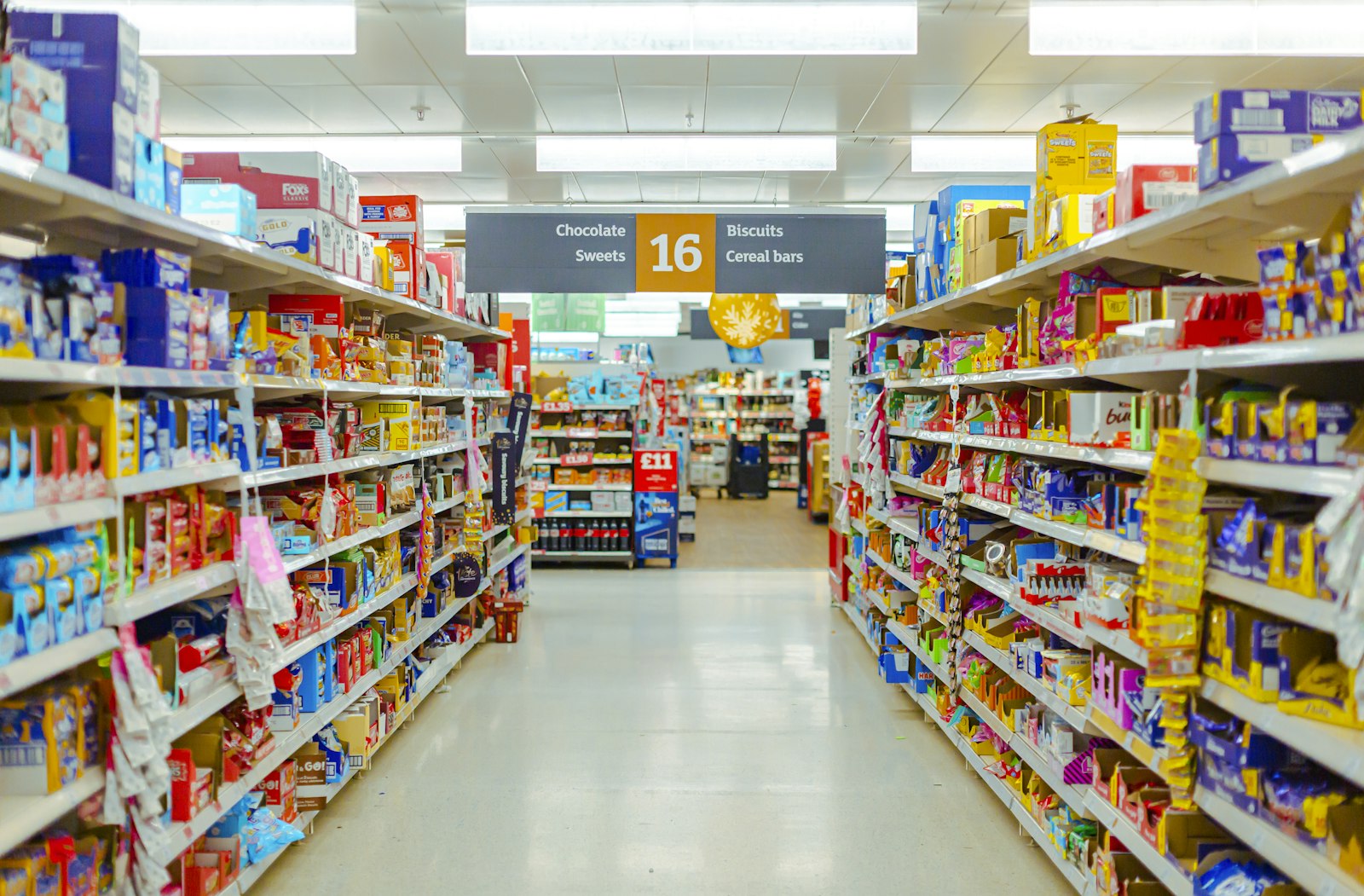 Corredor de supermercado com prateleiras cheias de produtos industrializados