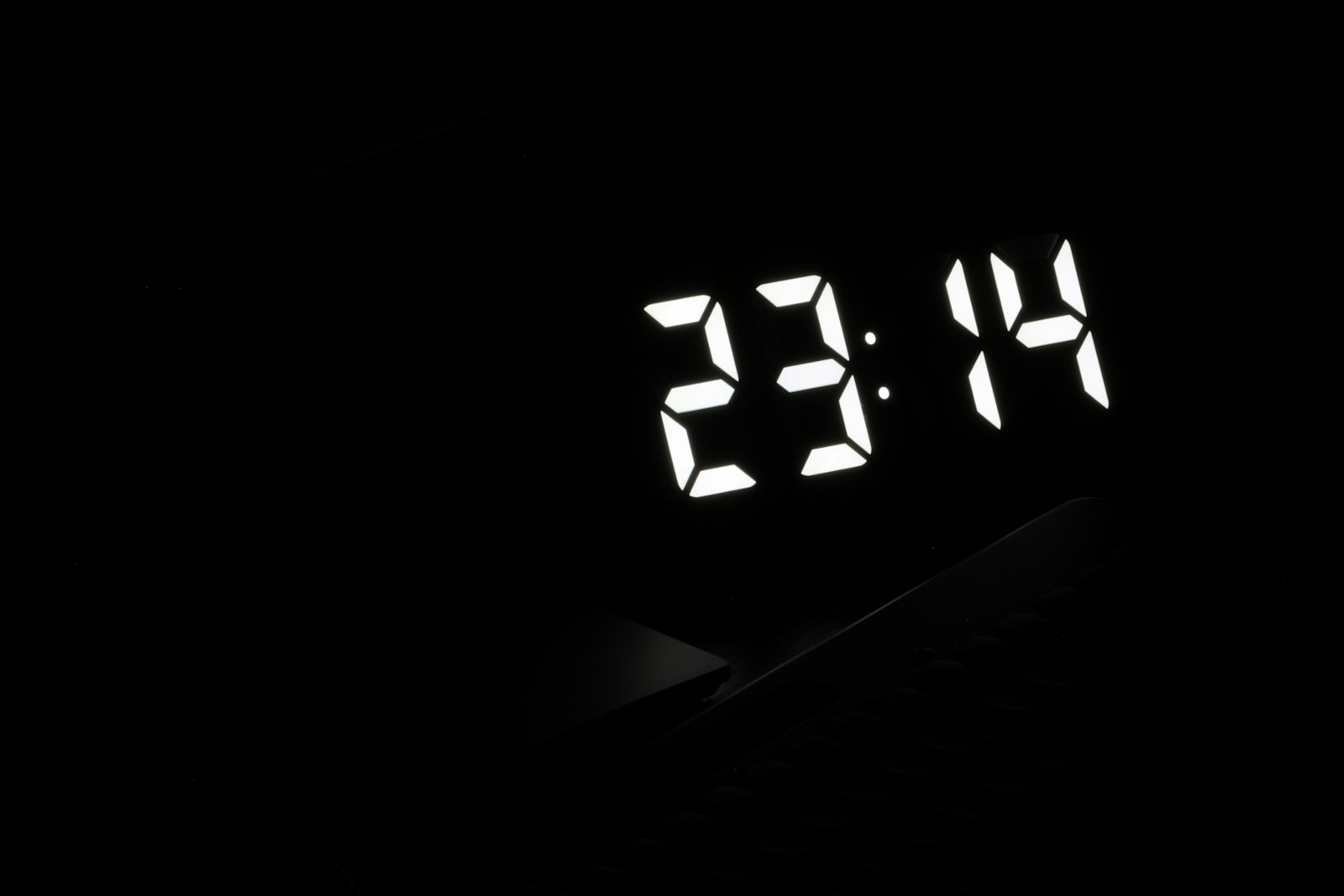 Relógio digital marcando 23h14 no escuro