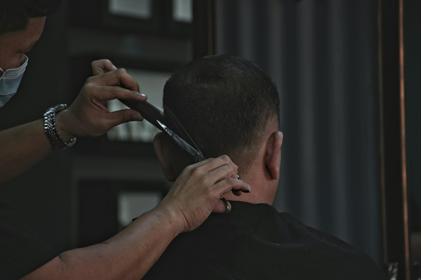 Barbeiro cortando o cabelo de um cliente na barbearia