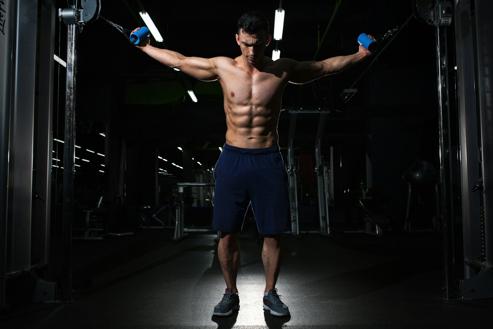 Homem treinando em uma academia com pouca luz
