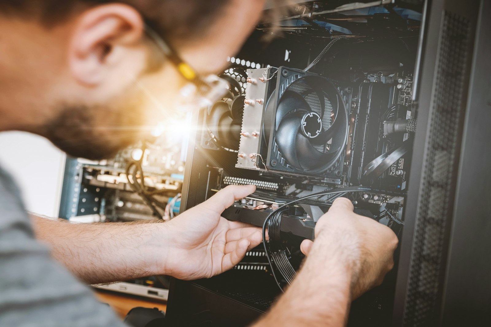 Pessoa instalando uma placa de video dentro do gabinete do computador