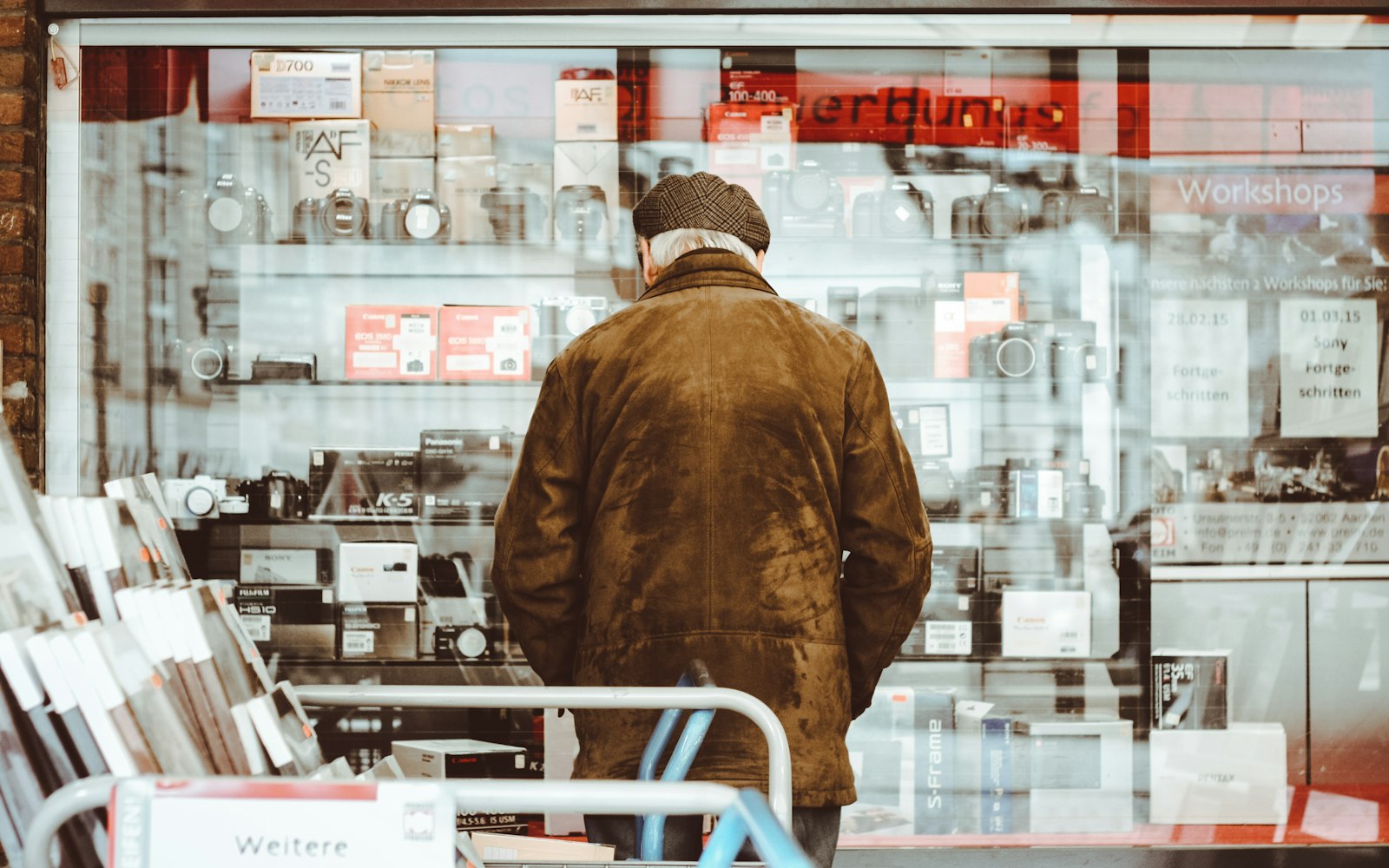 Homem de casaco observando produtos em uma vitrine de loja