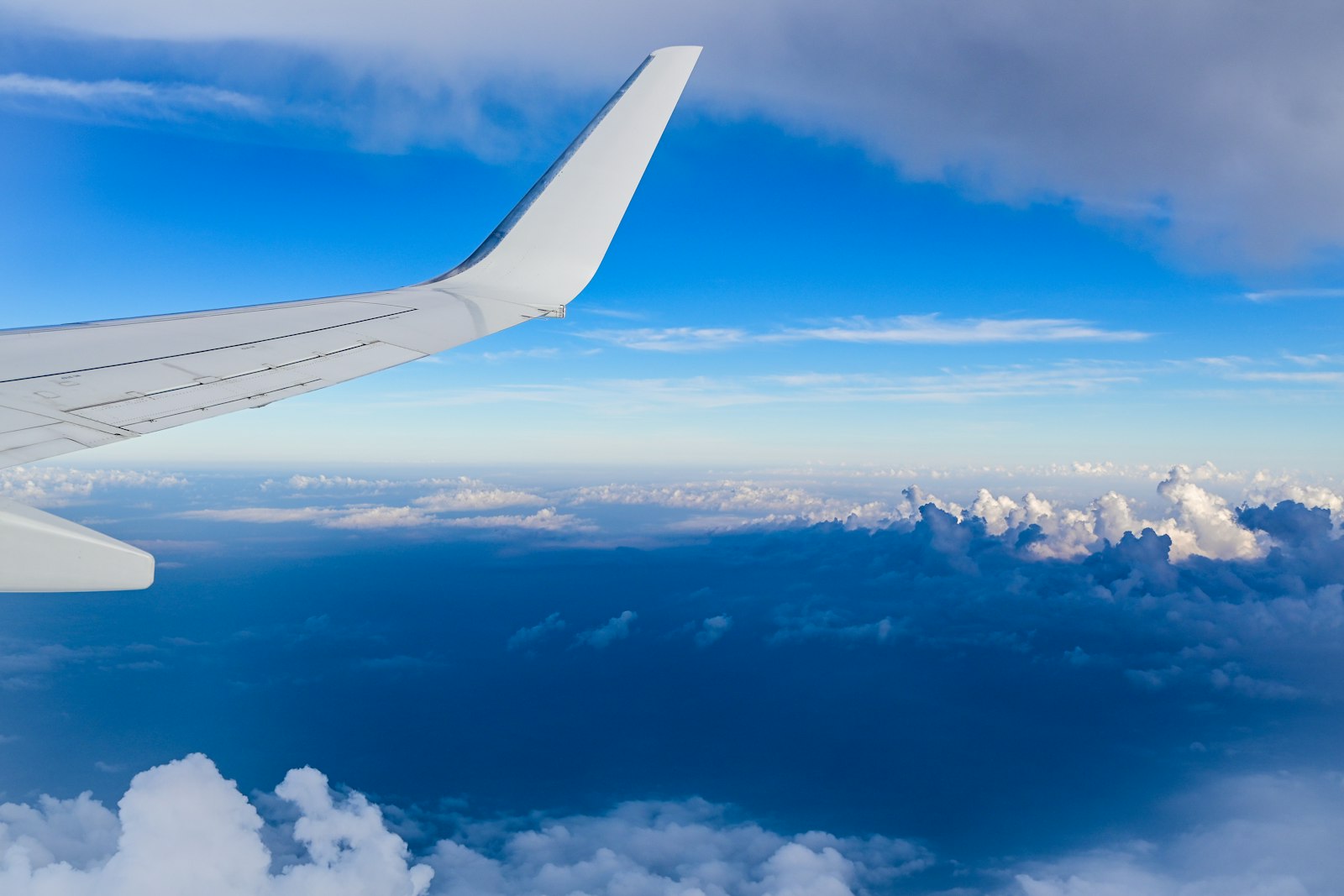 Asa de avião vista da janela sobre um mar de nuvens