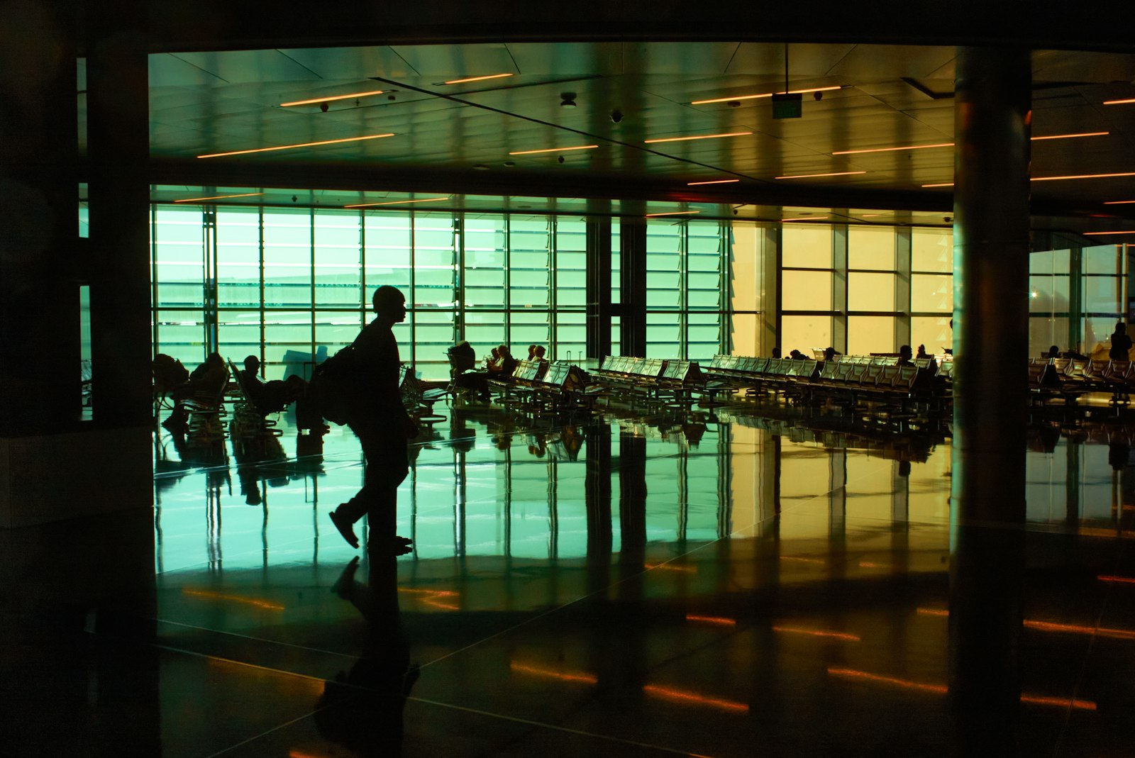 Homem caminhando sozinho por um terminal de aeroporto