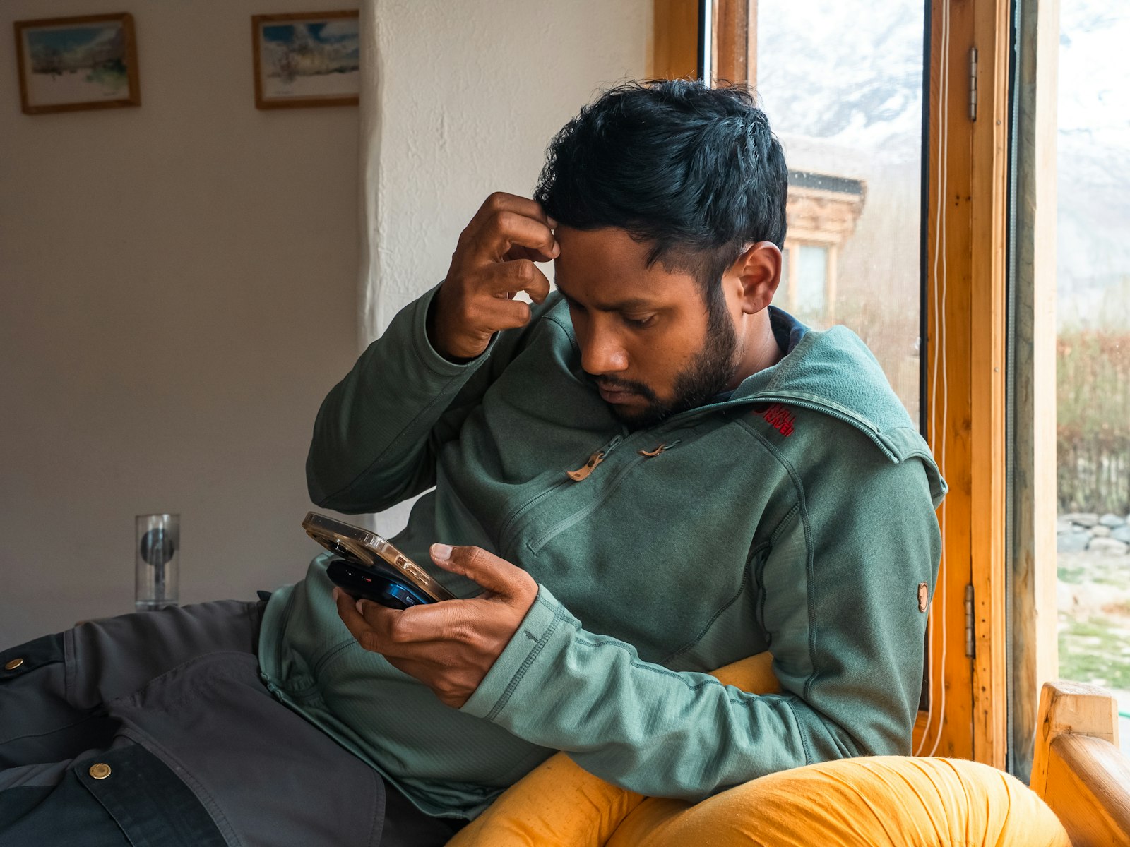 Homem olhando para a tela do celular com expressao de duvida