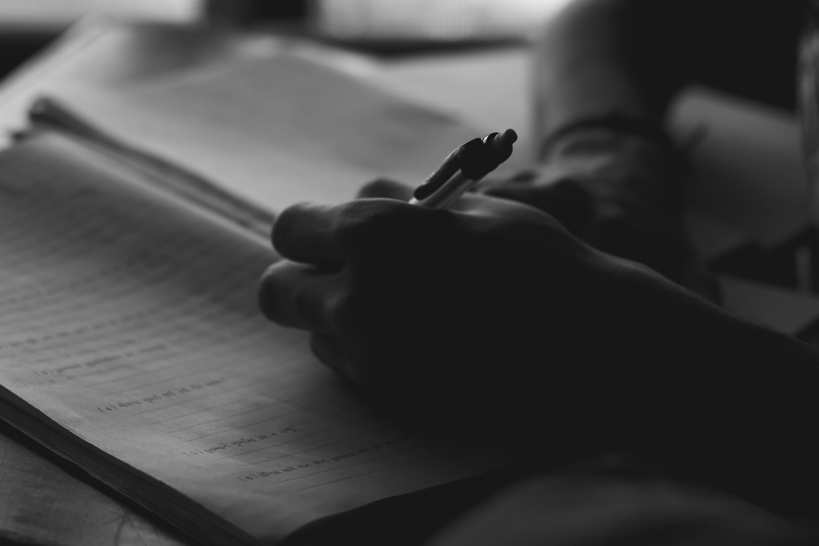 Pessoa escrevendo à mão em um caderno com caneta