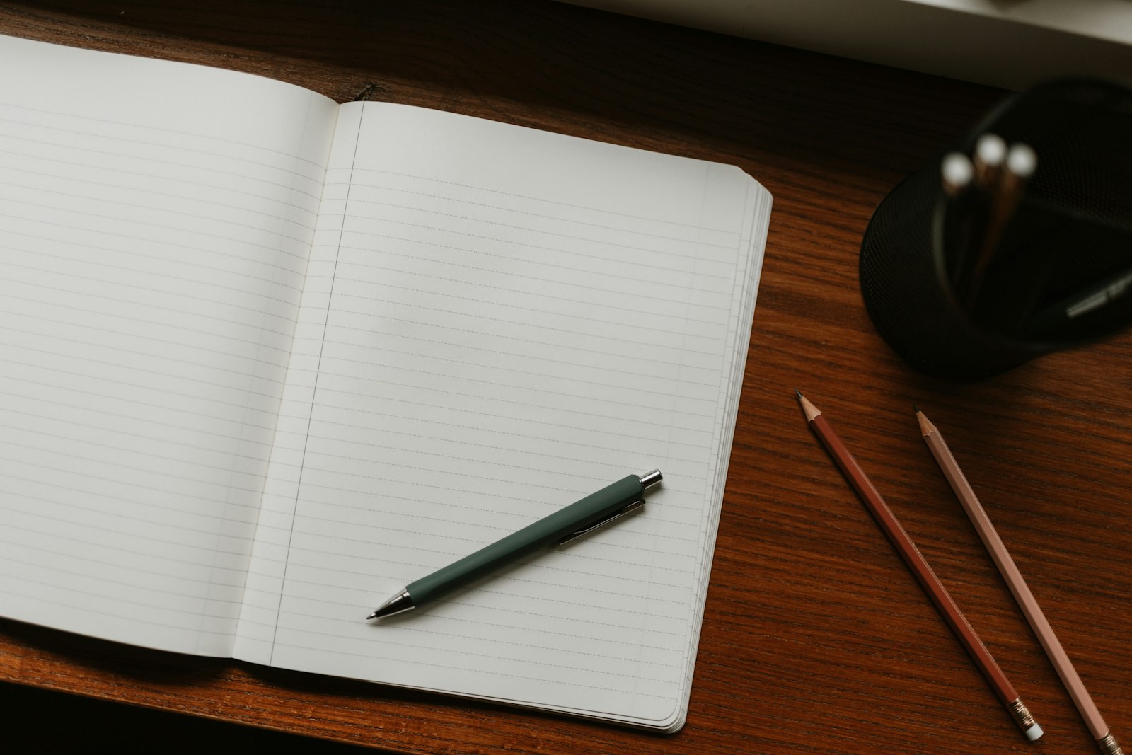 Caderno aberto com caneta sobre a mesa para anotar a lista de precos de referencia