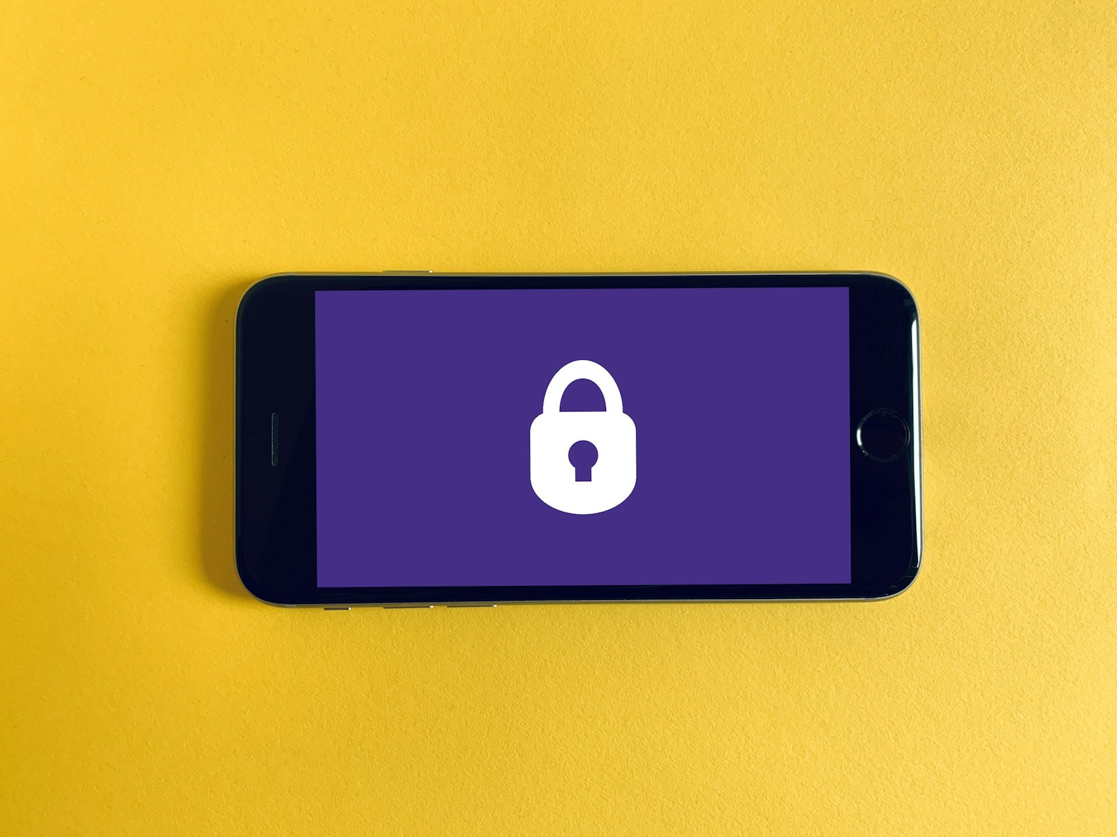 Cadeado fechado sobre a tela de um celular, simbolizando revisao de privacidade